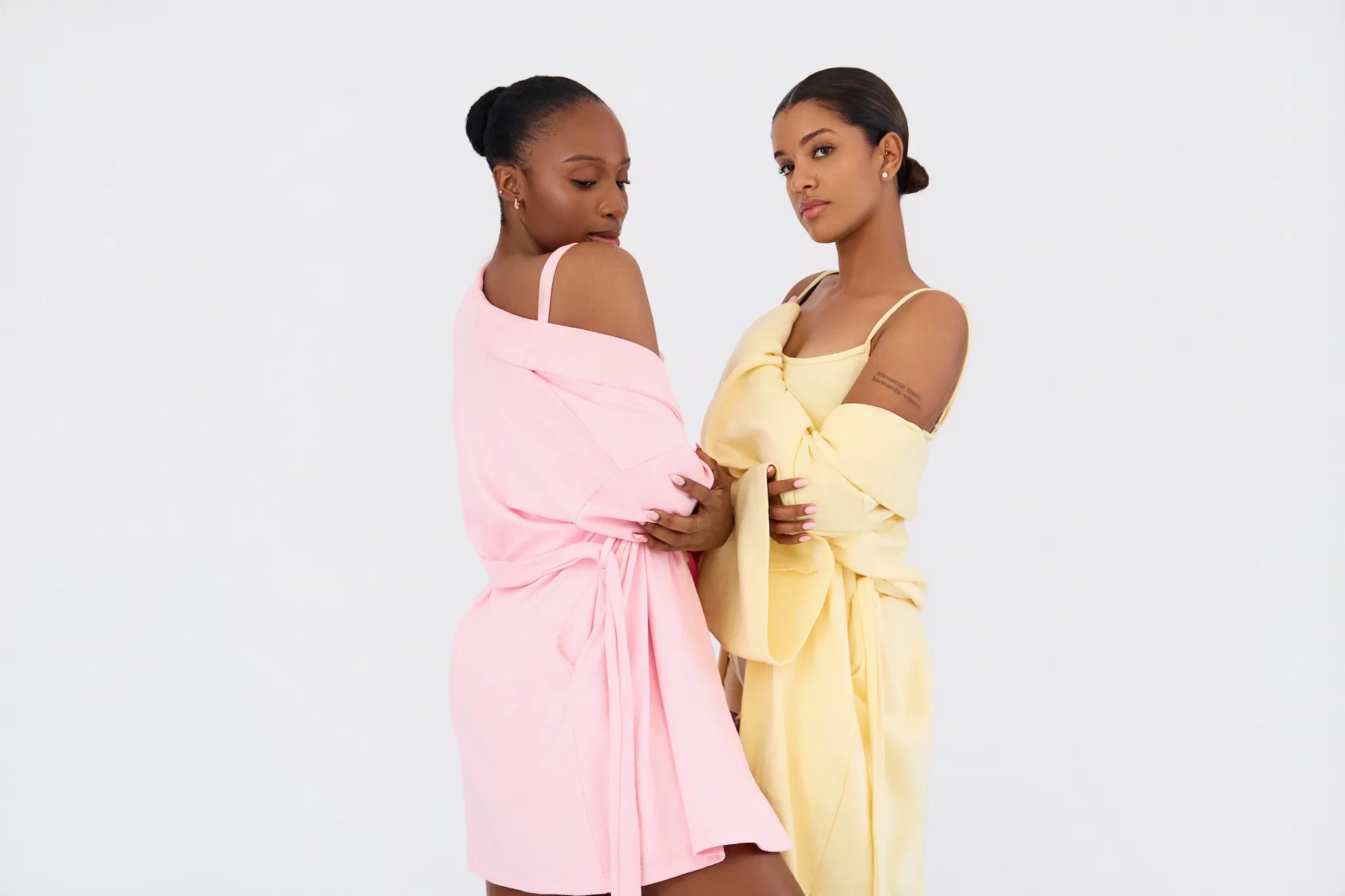 Two models wearing K|KASA Soft & Cozy layered set pajamas in Light Pink and Butter Yellow. Matching loungewear sets from the latest restock.